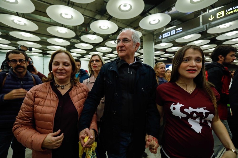 Mayor of Caracas, Antonio Ledezma center, is greeted by his wife Mitzy Capriles, second left, and his daughter Antoneta, right, upon his arrival to the Barajas Airport on  in Madrid on Saturday. — AFP