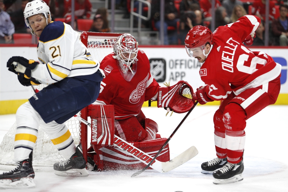 Detroit Red Wings defenseman Xavier Ouellet (61) looks to clear the puck away from goalie Jimmy Howard (35) and Buffalo Sabres right wing Kyle Okposo (21) during the third period at Little Caesars Arena. — Reuters