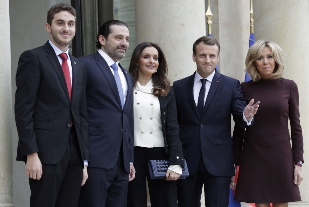 French President Emmanuel Macron  (4R) and his wife Brigitte Macron (R) welcome Lebanese Prime Minister Saad Hariri (2R), his wife Lara Bachir El-Alzm (3R) and their son Houssam (L)  at the Elysee Presidential Palace on Saturday in Paris. — AFP