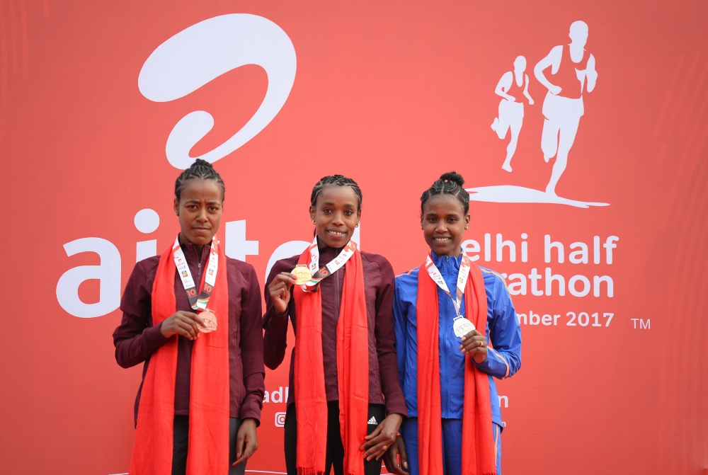 Almaz Ayana of Ethiopia (C) poses with her gold medal with Ababel Yeshaneh (R) of Ethiopia with silver medal and Netsanet Gudeta (L) of Ethiopia with her bronze medal after their win in women's Airtel Delhi Half Marathon 2017 in New Delhi on Sunday. — AFP