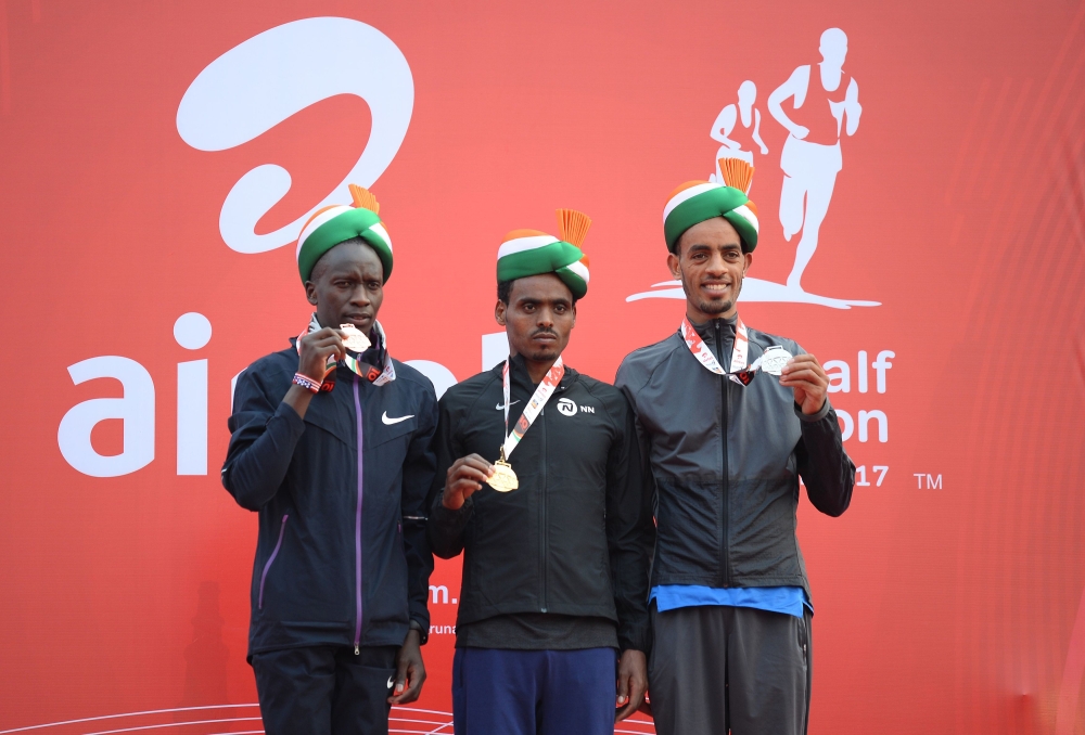 Almaz Ayana of Ethiopia (C) poses with her gold medal with Ababel Yeshaneh (R) of Ethiopia with silver medal and Netsanet Gudeta (L) of Ethiopia with her bronze medal after their win in women's Airtel Delhi Half Marathon 2017 in New Delhi on Sunday. — AFP