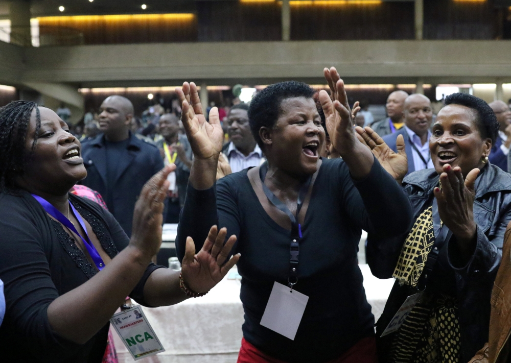 Delegates celebrate after Zimbabwean President Robert Mugabe was dismissed as party leader at an extraordinary meeting of the ruling ZANU-PF’s central committee in Harare, Zimbabwe, on Sunday. — Reuters