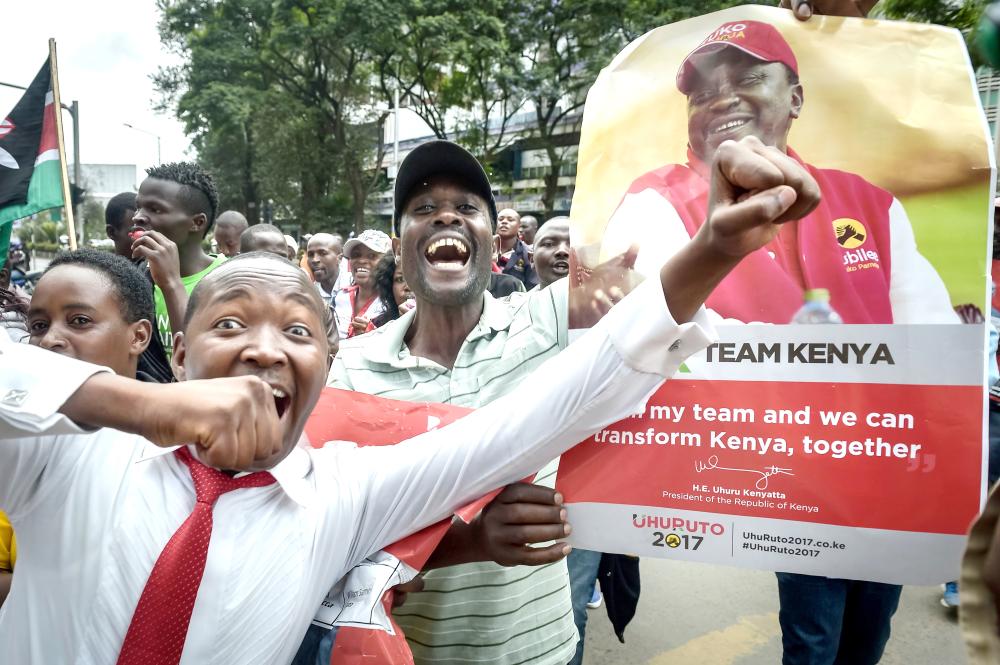 Supporters of President Uhuru Kenyatta celebrate on Monday in Nairobi after Kenya’s Supreme Court dismissed two petitions to overturn the country’s Oct. 26 presidential election re-run, validating the poll victory of Kenyatta. — AFP