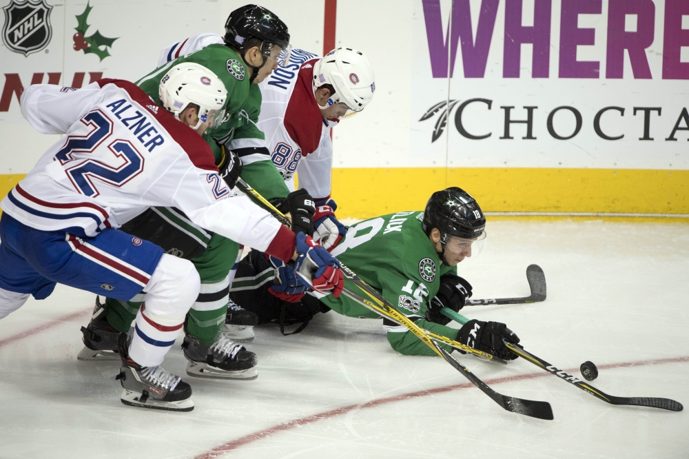Dallas Stars right wing Tyler Pitlick (18) and left wing Antoine Roussel (21) and Montreal Canadiens defenseman Karl Alzner (22) and defenseman Brandon Davidson (88) chase the puck during the third period at the American Airlines Center. The Stars defeat the Canadiens 3-1. — Reuters