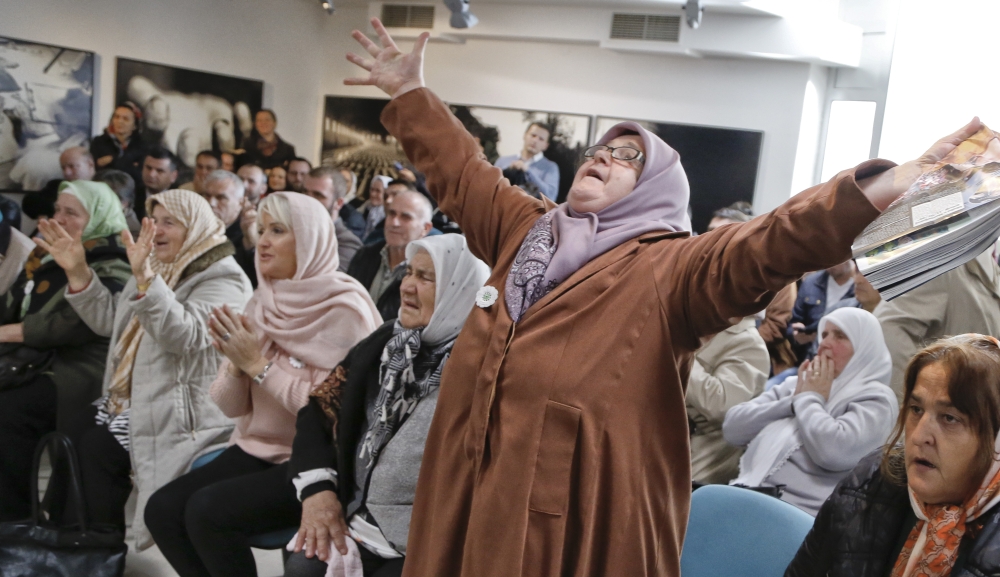 Ediba Salihovic, right, stands up and raises her hands as she reacts along with other Bosnian women upon hearing the sentence at the end of former Bosnian Serb military chief Gen. Ratko Mladic's trial at the memorial center in Potocari, near Srebrenica, Bosnia, on Wednesday. — AP