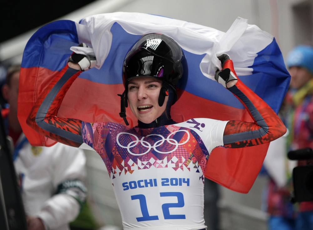 In this file photo, Elena Nikitina of Russia celebrates her bronze medal win during the women's skeleton competition at the 2014 Winter Olympics, in Krasnaya Polyana, Russia. The International Olympic Committee has banned four more Russians for doping at the 2014 Sochi Winter Olympics, all competing in the sliding sport of skeleton and includes men’s gold medalist Alexander Tretyakov and women’s bronze medalist Elena Nikitina. — AP