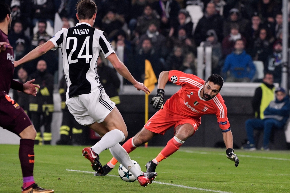 Juventus' goalkeeper from Italy Gianluigi Buffon (R) makes a save during the UEFA Champions League Group D football match Juventus Barcelona on Wednesday at the Juventus stadium in Turin.  Barcelona advanced to the Champions League last 16 on Wednesday after clinching top spot in Group D following a 0-0 draw against Juventus in Turin. — AFP