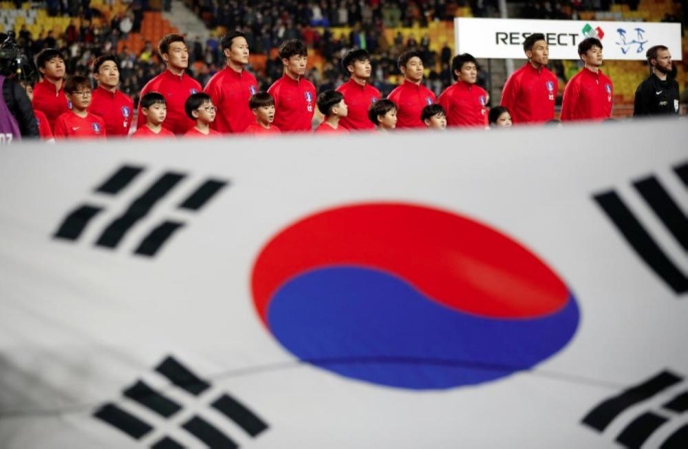 South Korea's national soccer team members stand behind the national flag prior to the International Friendly tie against Colombia at the Suwon World Cup Stadium, Suwon, South Korea. — Reuter