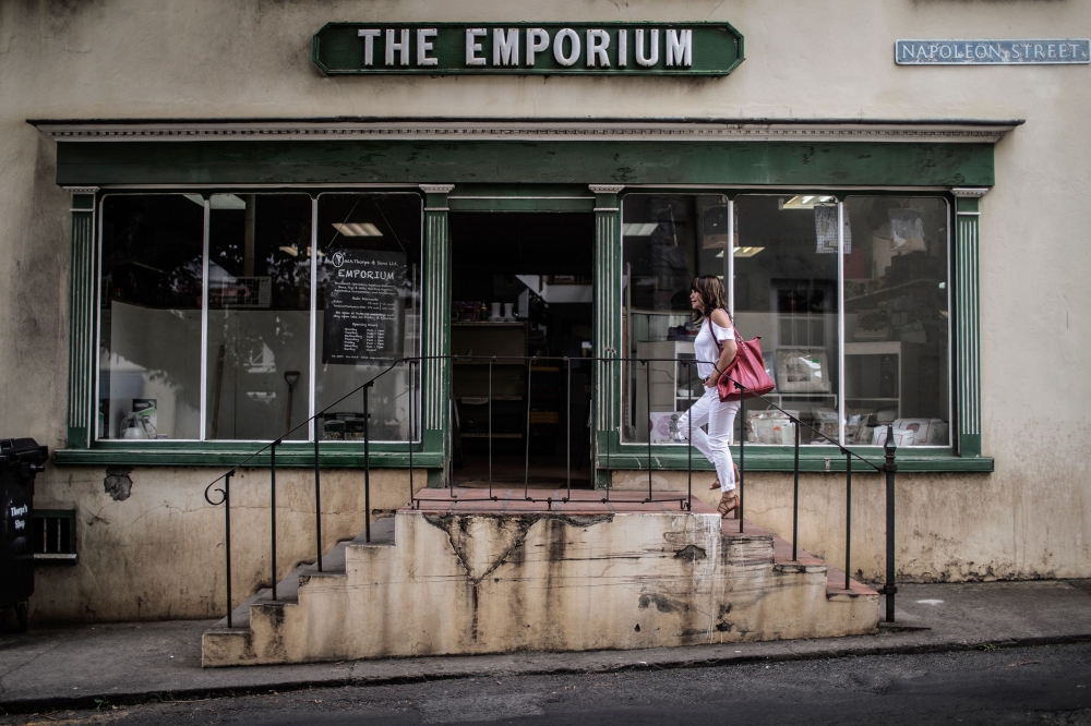 Awoman walks up the stairs of a wholesale shop on Napoleon Street in Jamestown in the British Overseas Territory of Saint Helena. Coin-operated telephone boxes, a capital without a cash machine and a local shop with a wooden floor: St. Helena is Britain of yesteryear, in the middle of the Atlantic Ocean. — AFP