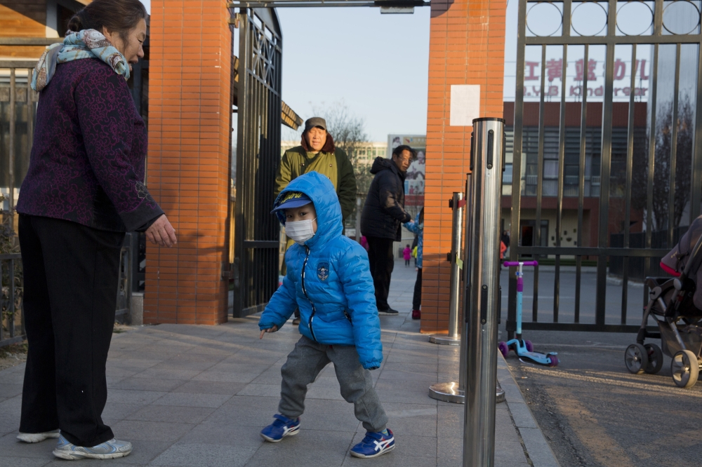 A child arrives to attend the RYB kindergarten in Beijing on Friday. — AP