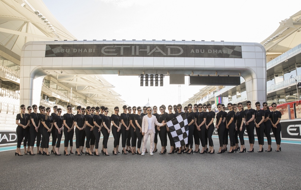 Prabal Gurung poses with the Abu Dhabi Grand Prix Grid Girls at Yas Marina Circuit 

