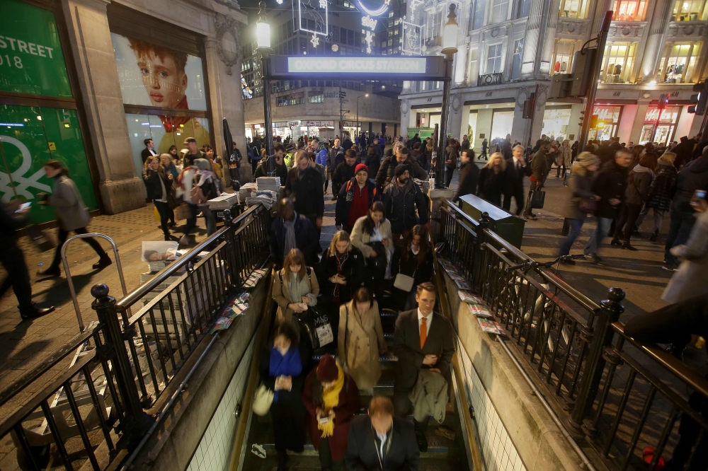Commuters descend the stairs to catch the tube at Oxford Circus Station in central London on Friday. — AFP