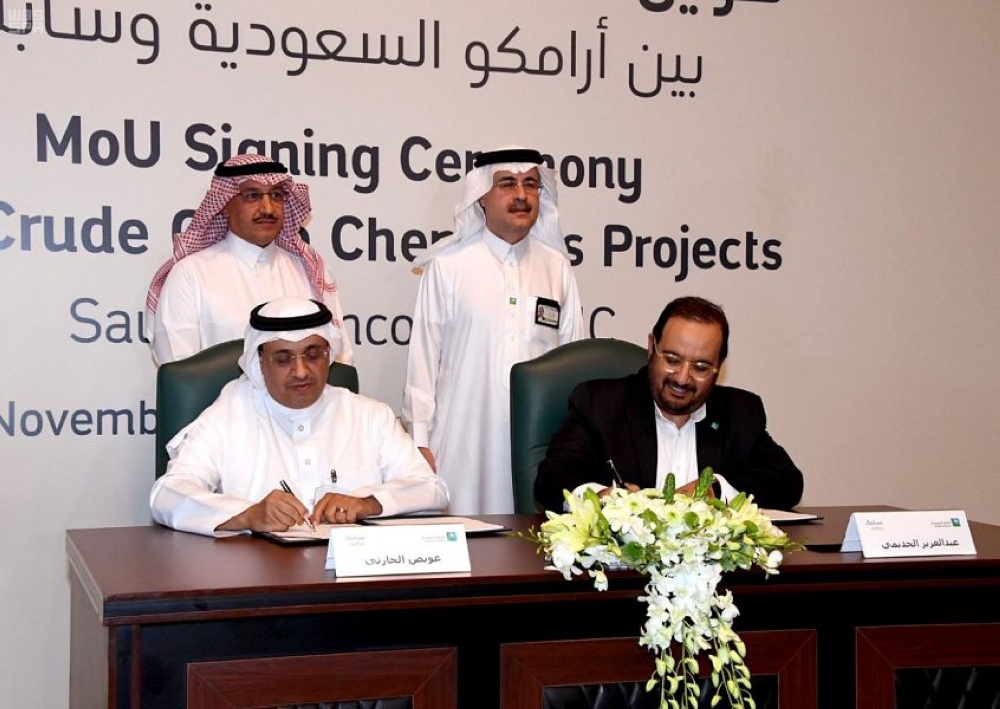 Aramco Chief Executive Amin Nasser (standing right) and SABIC’s chief executive Yousef Al-Benyan (standing left) oversee the signing of a memorandum of understanding on Sunday.
