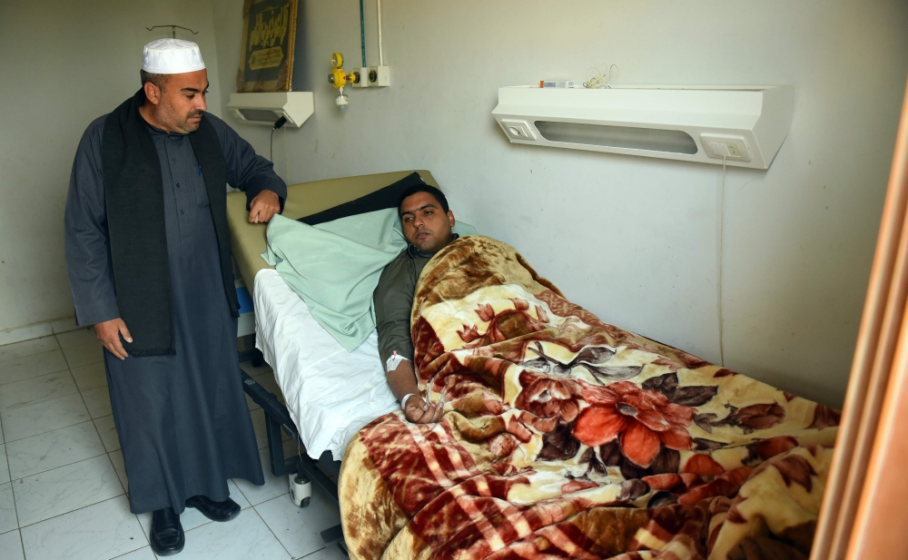 Mohamed Abdel Fattah (R), the imam of Rawda mosque which was attacked by militants near the North Sinai provincial capital of El-Arish, receives treatment at Al-Husseiniya hospital in Egypt's northern province of Al-Sharqiya. — AFP