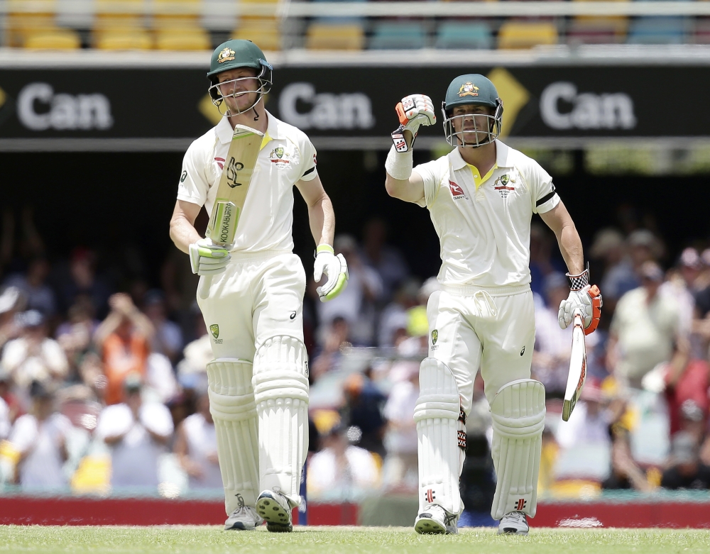 Australia's David Warner, right, and Cameron Bancroft walk off the field after winning the match against England during their Ashes cricket Test in Brisbane, Australia, Monday. — AP