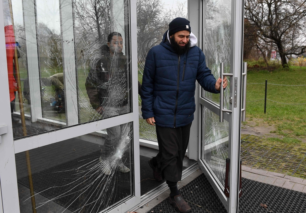 People leave the Muslim Cultural Centre in Warsaw on Monday, after the building was vandalized. — AFP