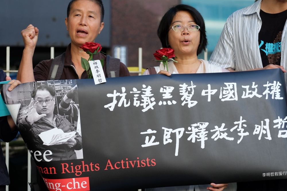 Human rights activists display a banner of jailed Taiwanese NGO worker Lee Ming-cheh during a protest in Taipei on Tuesday. — AFP