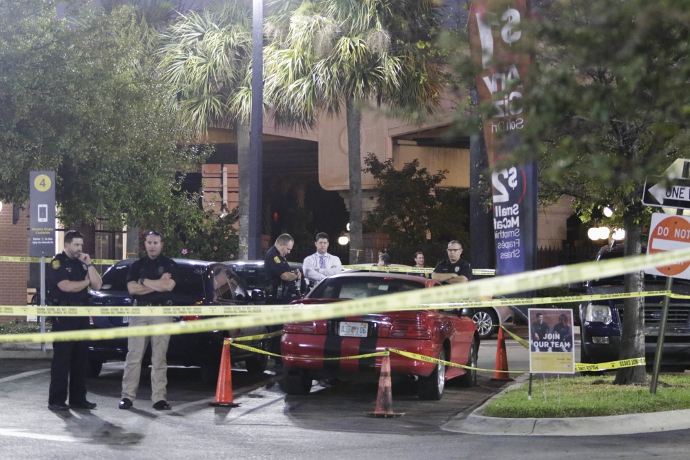 Officers are processing possible evidence and a red sports car at a McDonalds in Ybor City in Tampa, Florida, on Tuesday. — AP