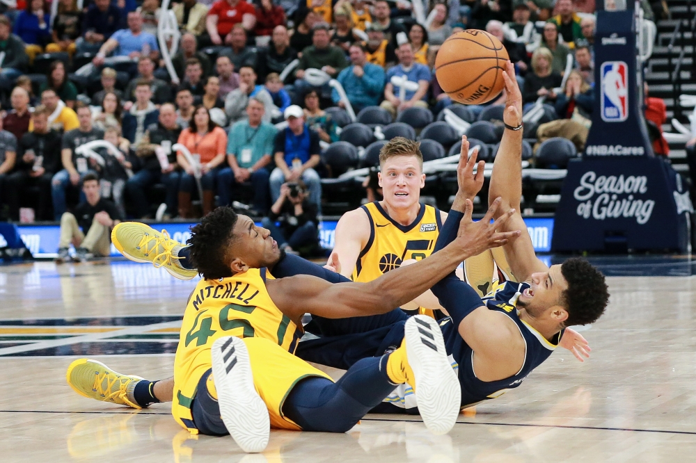 Utah Jazz guard Donovan Mitchell (45) and Denver Nuggets guard Jamal Murray (27) fight for the loose ball during the second half at Vivint Smart Home Arena. The Jazz won 106-77. — Reuters