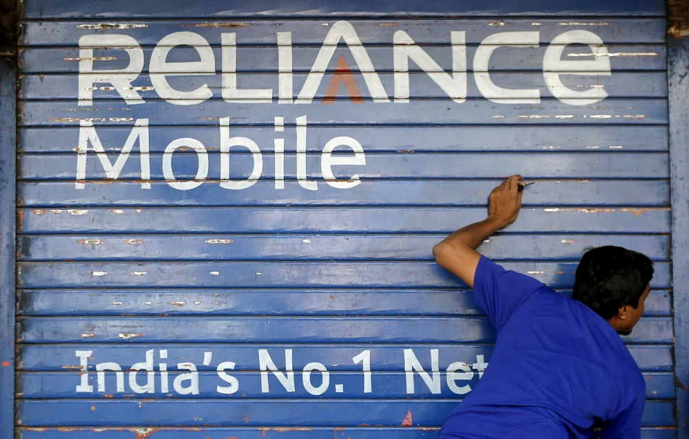 A man opens the shutter of a shop painted with an advertisement of Reliance Communications in Mumbai, India, in this file photo.    Indian economy grew at 6.3 percent in the second quarter of the financial year, official data showed Thursday, rebounding from a sharp slowdown in the wake of high-profile reforms. — Reuters