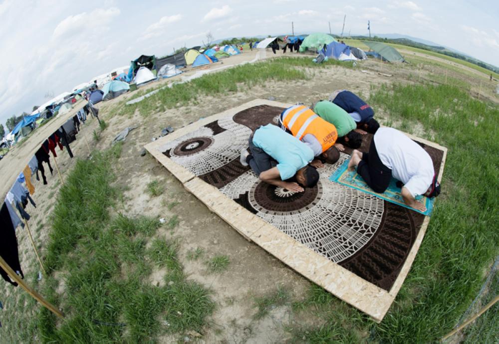 Muslims pray at a makeshift camp for migrants and refugees near the village of Idomeni not far from the Greek-Macedonian border. — AFP