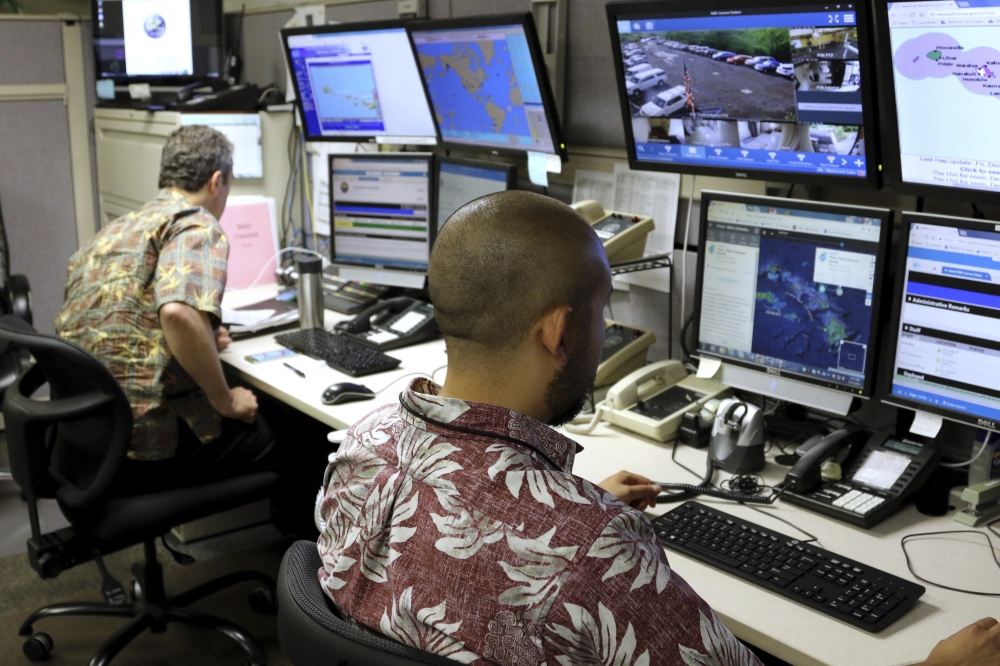 Hawaii Emergency Management Agency officials work at the department’s command center in Honolulu on Friday. — AP