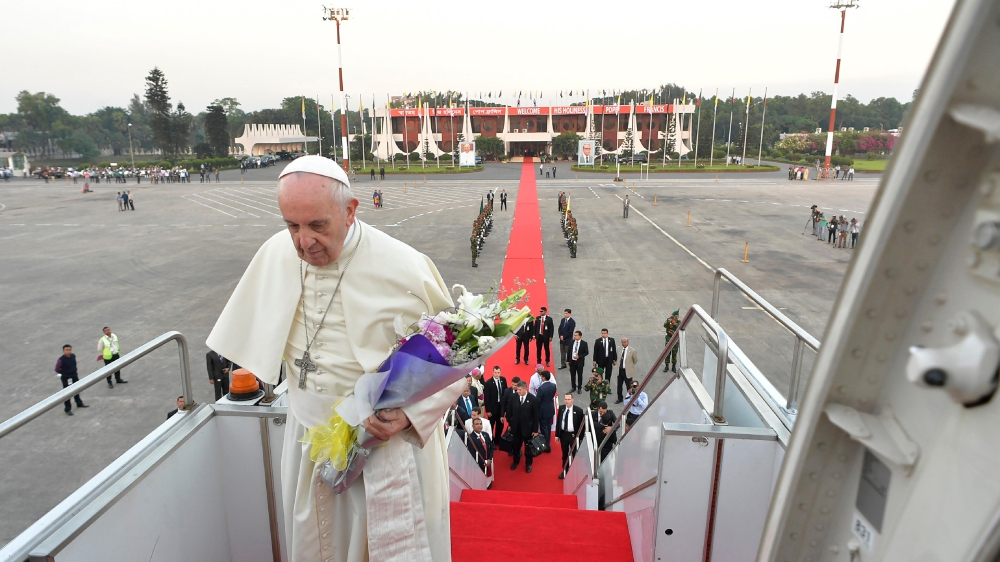 Pope Francis walks up the stairs before boarding a plane after his three-day visit to Bangladesh in Dhaka on Saturday. — AFP