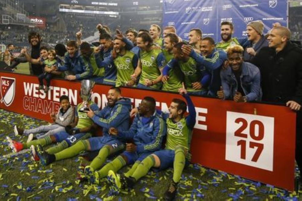 The Seattle Sounders FC including midfielder Clint Dempsey (with trophy) celebrate after beating the Houston Dynamo in the second leg of the Western Conference championship at CenturyLink Field. — Reuters