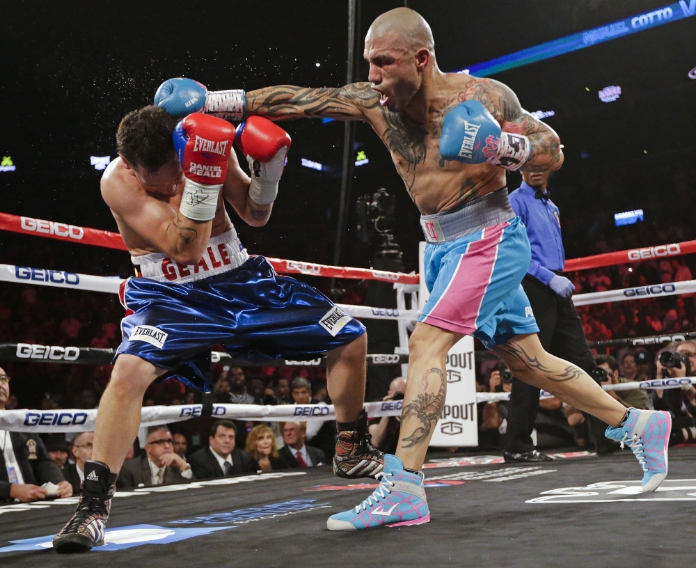 In this file photo, Miguel Cotto, right, of Puerto Rico, punches Daniel Geale, of Australia, during the second round of a boxing match in New York. Cotto is a boxing icon in Puerto Rico. In New York City, too. On Saturday night the most popular boxer of his generation from the Caribbean island that has produced so many champions will finish off his terrific career at Madison Square Garden with a title fight. — AP
