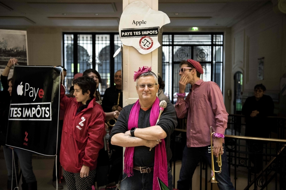 Activists of the Association for the Taxation of Financial Transactions and Citizen's Action (ATTAC) stage a protest against alleged tax evasion by US multinational technology company Apple at an Apple store in Paris on Dec. 2, 2017 — AFP 