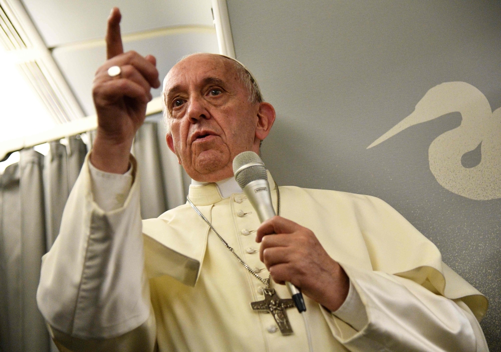 Pope Francis gestures during a news conference on board of a plane on Saturday, during a flight back from a seven-day trip to Myanmar and Bangladesh. — AFP