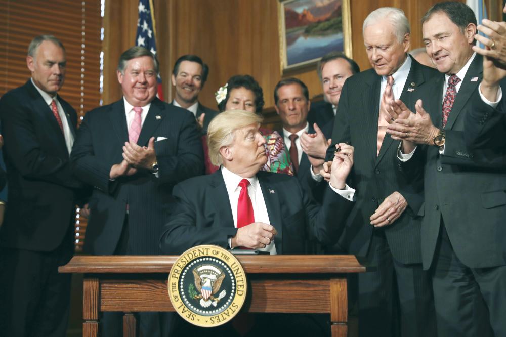 President Donald Trump hands a pen to Sen. Orrin Hatch, R-Utah after signing an Antiquities Executive Order during a ceremony at the Interior Department in Washington in this April, 26, 2017 file photo. — AP