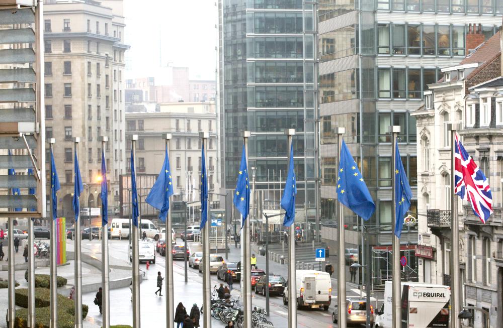 The British, right, and EU flags flap in the wind outside EU headquarters in Brussels on Monday.  — AP