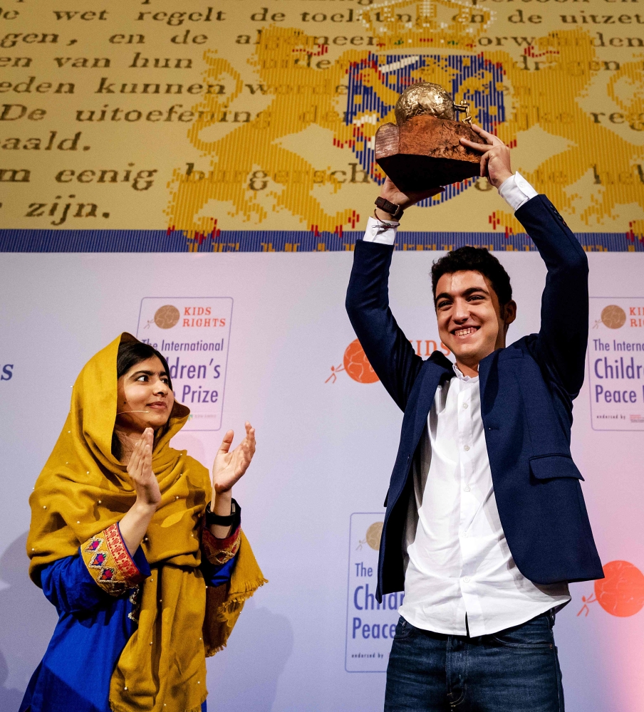 16-year old Syrian Mohamad Al Jounde (R) celebrates after receiving the International Children's Peace Prize, given to him by Pakistani activist and Nobel Peace Prize laureate Malala Yousafzai at the Ridderzaal in the Hague. — AFP