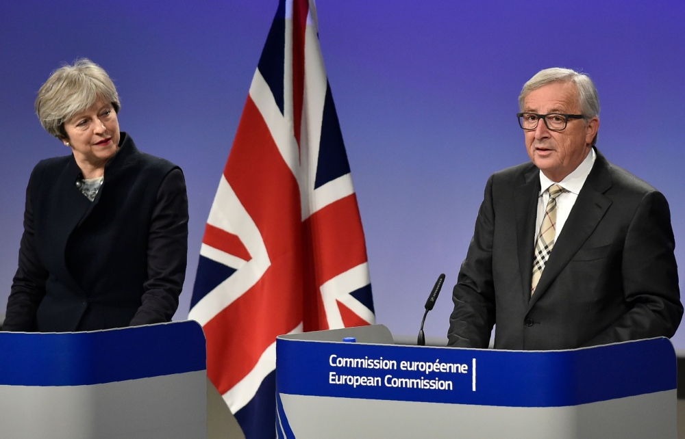 British Prime Minister Theresa May, left, and European Commission chief Jean-Claude Juncker give a press conference as they meet for Brexit negotiations at the European Commission in Brussels on Monday. — AFP