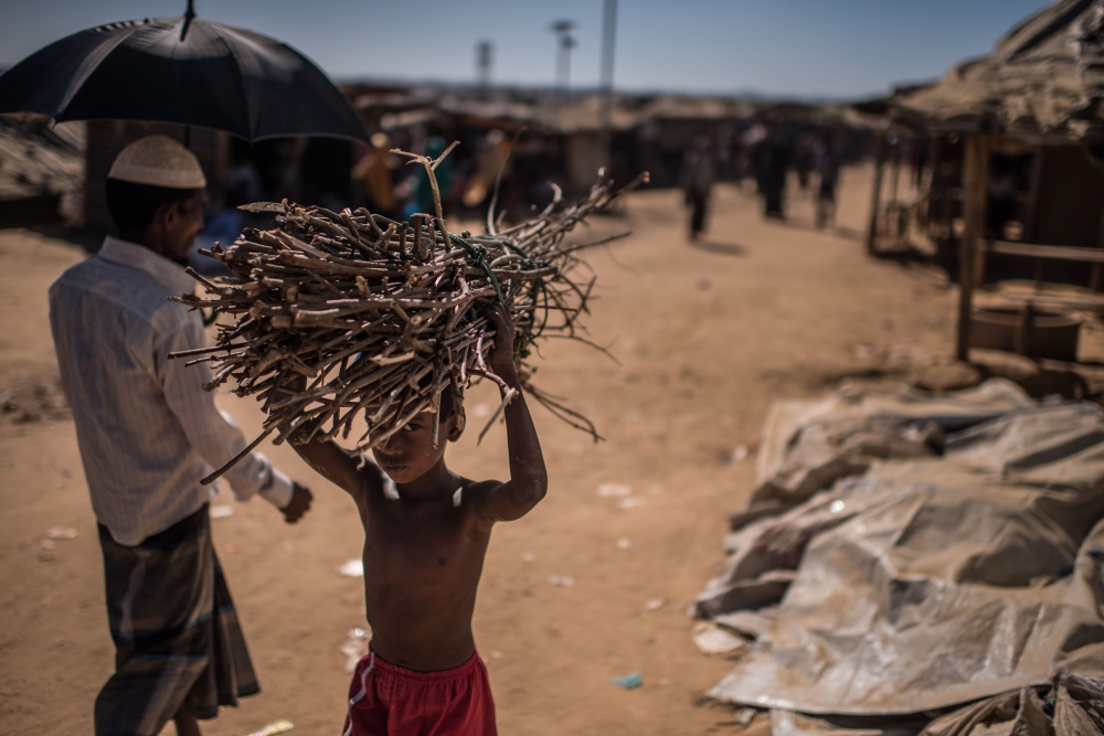 A young Rohingya refugee carries firewood as he walks through the Kutupalong refugee camp in Cox’s Bazar, Bangladesh, on Monday. — AFP