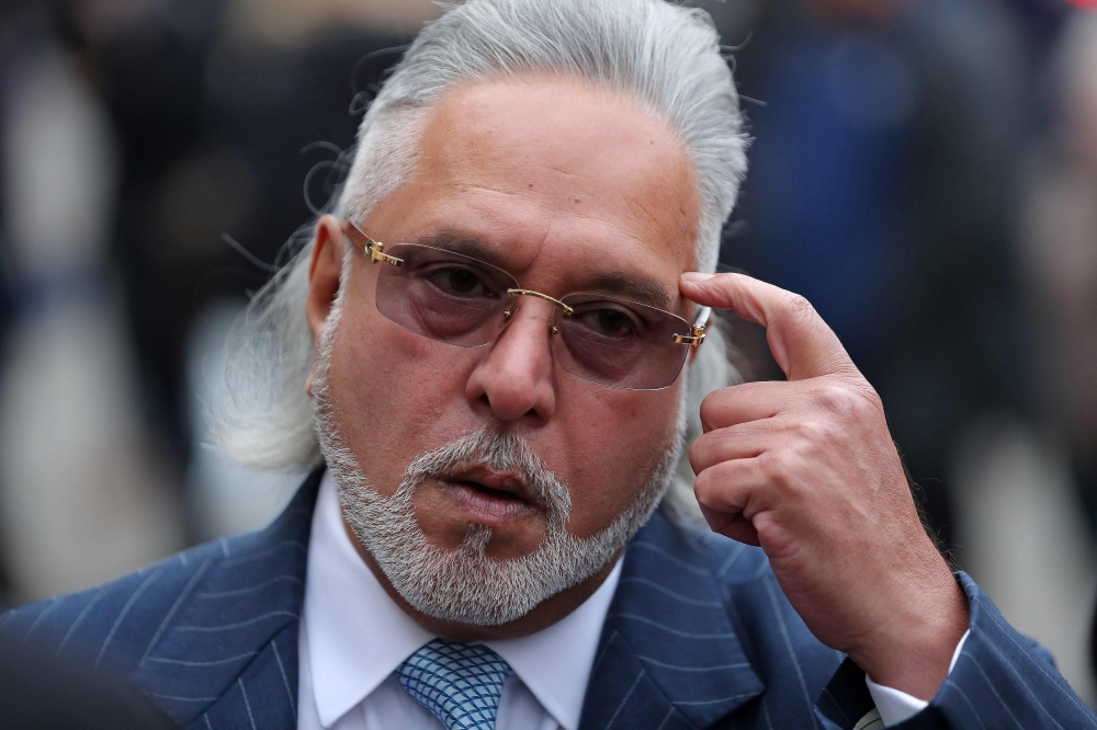 Indian tycoon Vijay Mallya reacts as he waits to re-enter Westminster Magistrates Court in central London on Monday. — AFP