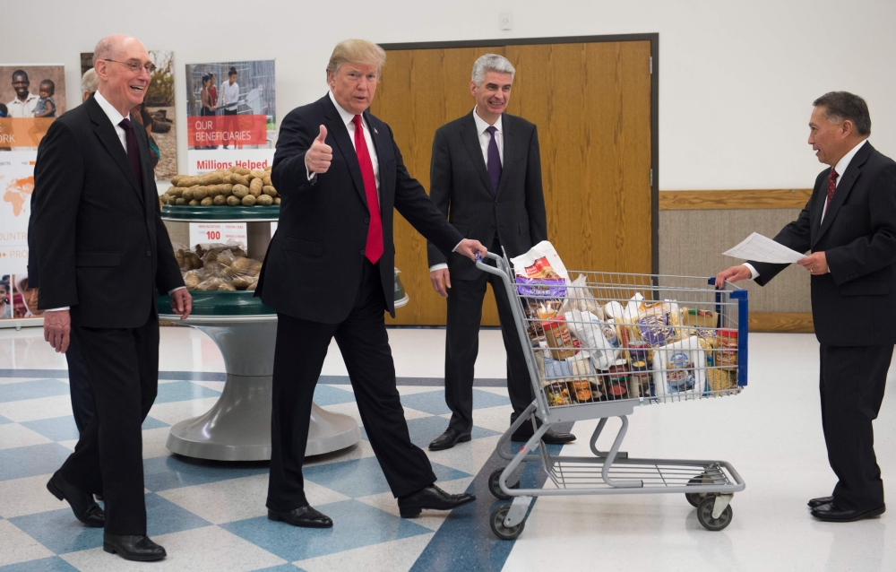 US President Donald Trump pushes a shopping cart as he tours a food distribution center at LDS Welfare Square in Salt Lake City, Utah, on Monday. — AFP