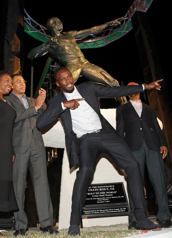 Olympic champion Usain Bolt (C) poses after the unveiling of his statue at the Statue Park at the National Stadium, in Kingston, Jamaica on Sunday.  — Reuters