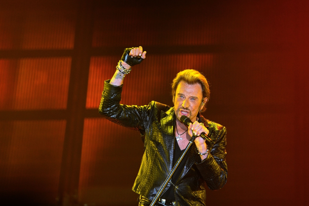 This June 2, 2013 file photo shows French singer Johnny Hallyday gesturing as he performs on stage in Bordeaux, southwestern France. - AFP