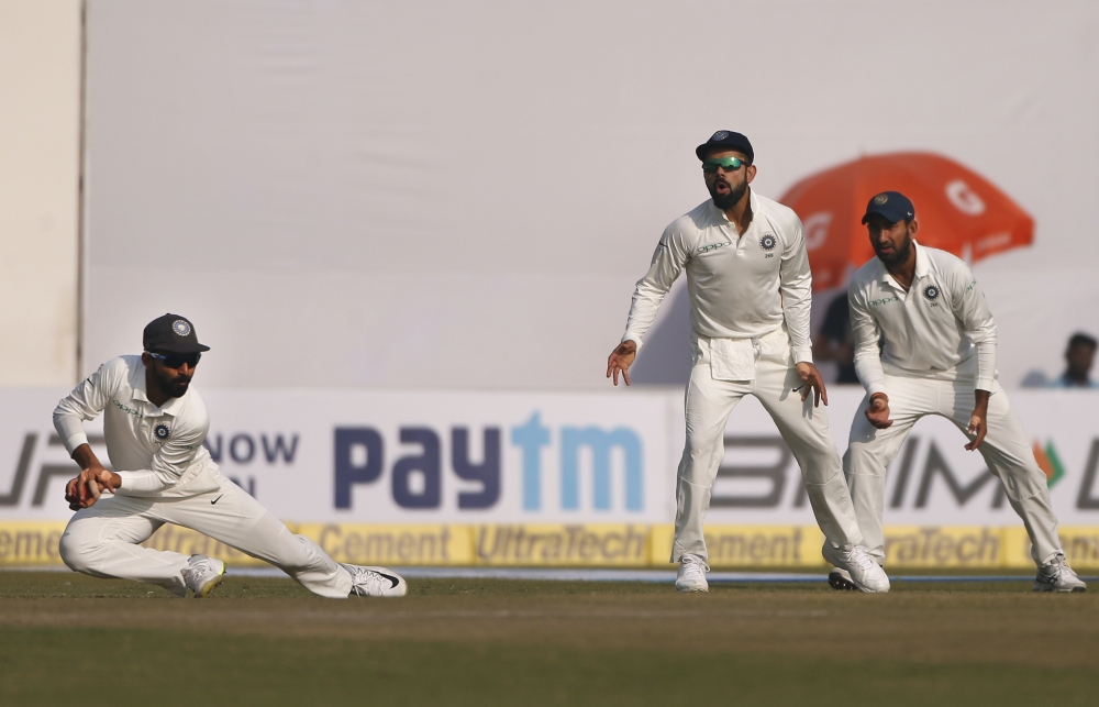 India's captain Virat Kohli, second right, and Cheteshwar Pujara, right, watch teammate Ajinkya Rahane, left, field the ball during the fifth day of their third Test cricket match against Sri Lanka in New Delhi, India, Wednesday. — AP