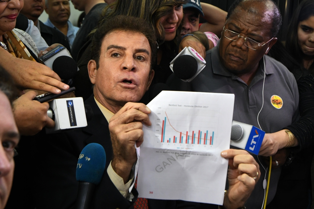 The presidential candidate for Honduras’  Opposition Alliance against the Dictatorship, Salvador Nasralla, center left, gestures as he meets with coordinator of the Electoral Supreme Tribunal, Leticia Henriquez (not pictured), to present a document asking to annul the results of the still-unresolved Nov. 26 vote, in Tegucigalpa on Saturday. — AFP
