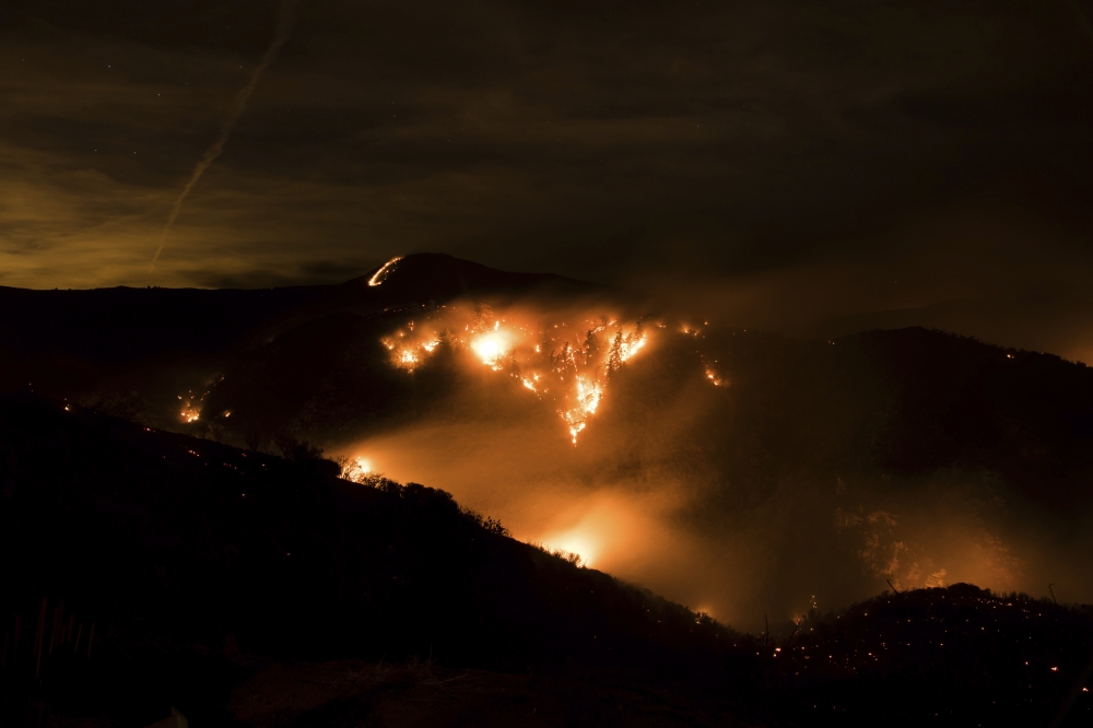 A hillside glows with embers as a wildfire burns through Los Padres National Forest near Ojai, California, on Friday. — AP