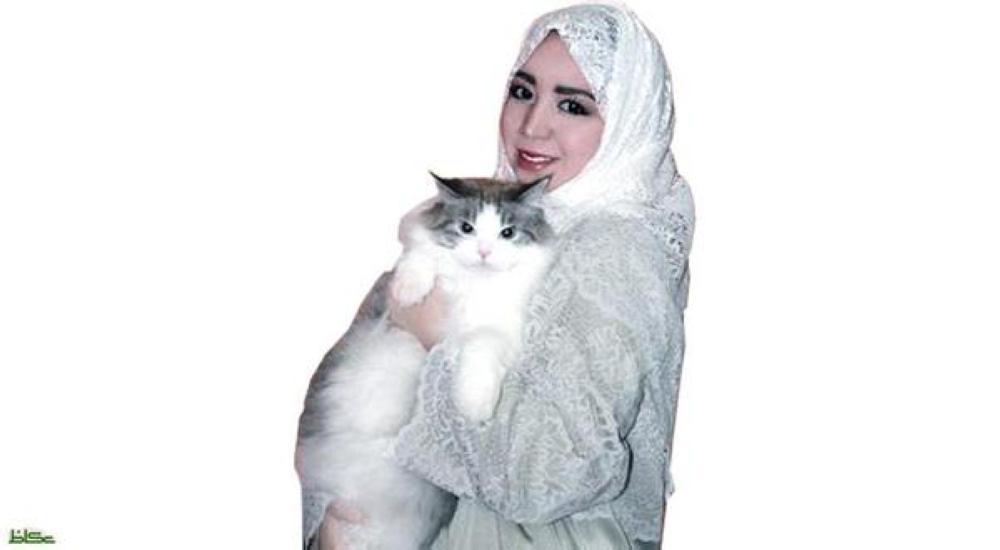 Sarah Abdel Fattah holding one of the cats in her care.