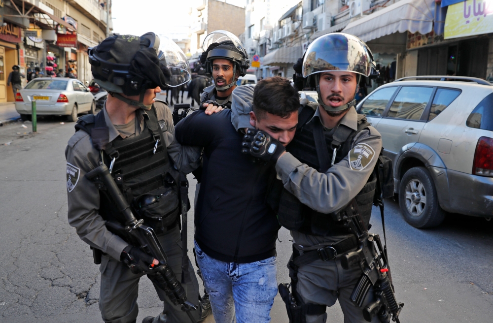 Israeli security forces detain a Palestinian in East Jerusalem on Saturday. Israeli air strikes on the Gaza Strip killed two Palestinians as unrest simmered across the Palestinian territories over US President Donald Trump's declaration of Jerusalem as Israel's capital. — AFP