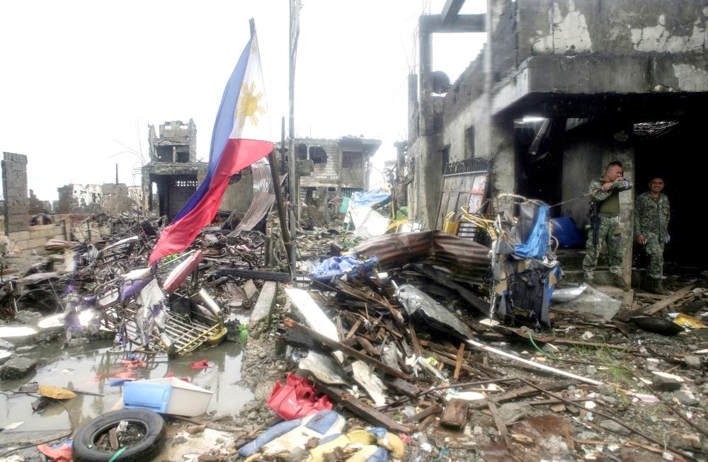 A Philippine flag is seen at destroyed houses in Bangolo town at Marawi city, southern Philippines, in this Oct.17, 2017 file photo.  — Reuters