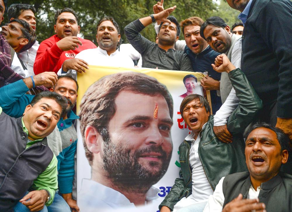 Indian supporters of the Congress Party shout slogans after the party named Rahul Gandhi president outside Congress headquarters in New Delhi on Monday. — AFP