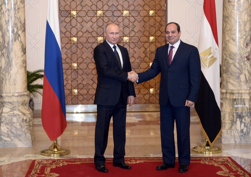 Russian President Vladimir Putin (L) shakes hands with his Egyptian counterpart Abdel Fattah El-Sisi during a meeting in Cairo on Monday. — AFP