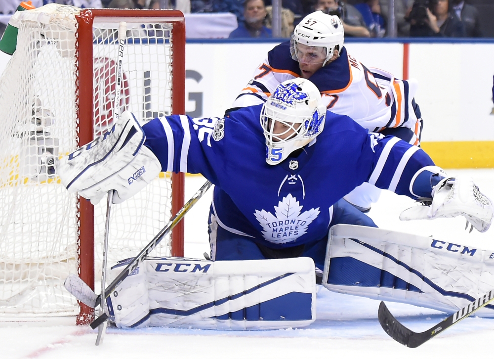 Toronto Maple Leafs goalie Curtis McElhinney (35) makes a save as Edmonton Oilers forward Connor McDavid (97) reaches for the puck in the third period at Air Canada Centre. — Reuters