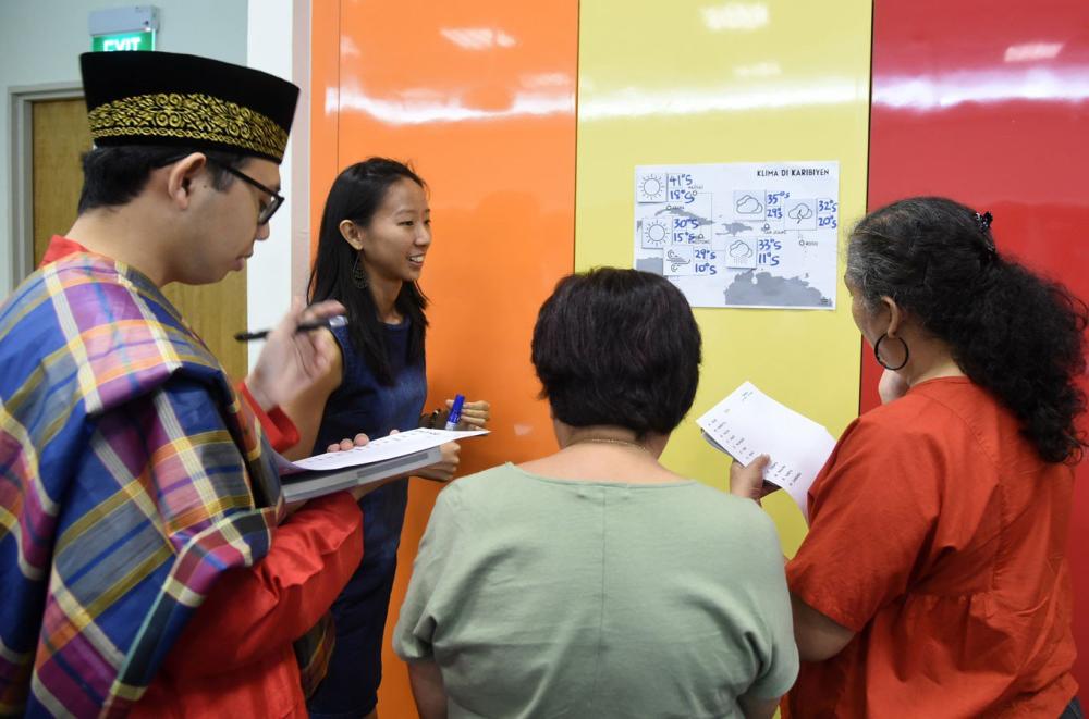 This photograph taken on Oct. 19, 2017 shows students from various cultures in a group discussion during their Kristang language class session at the national library board in Singapore. Kevin Martens Wong reels off melodic sentences in Kristang, one of several minority languages enjoying a new lease of life in Singapore after a decades-long, state-led drive to encourage the use of English and Mandarin. - AFP